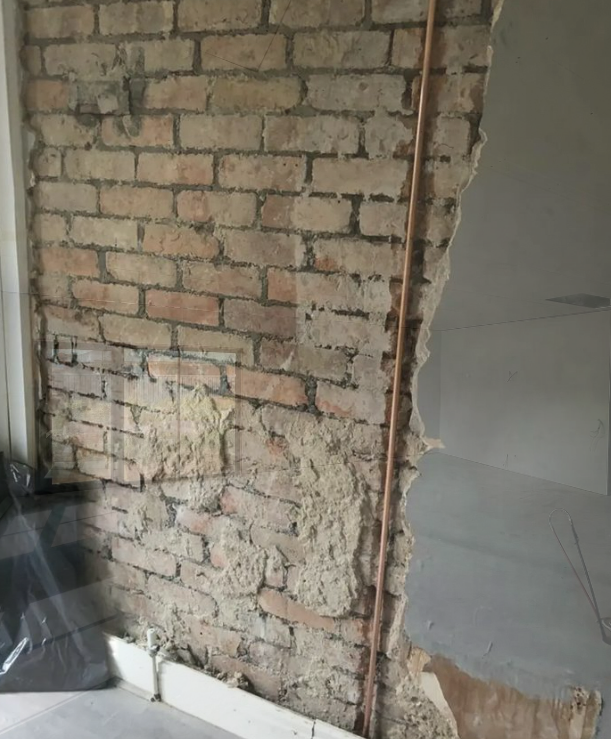 an image of a plasterboard removed to reveal bricked wall