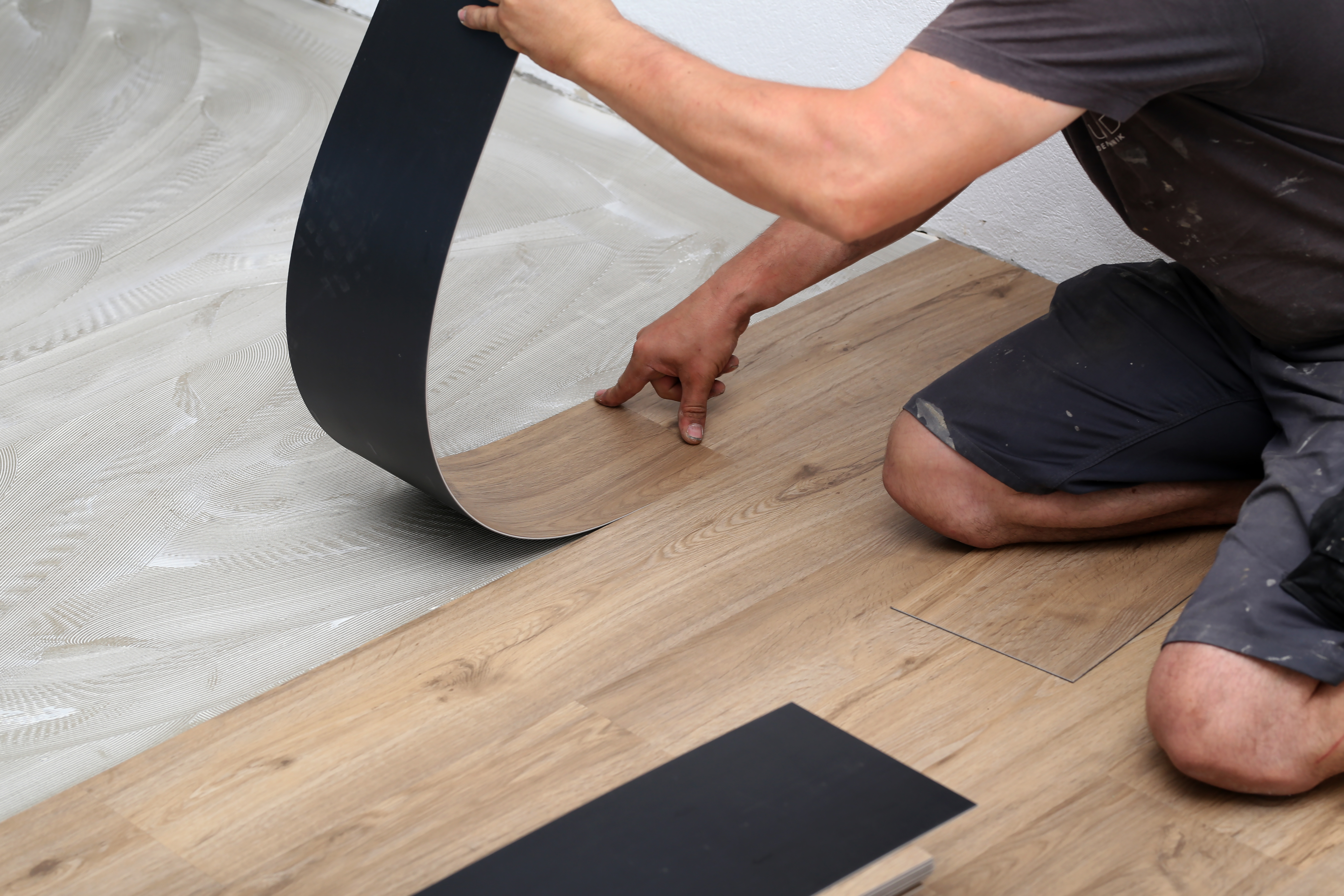 A worker installing vinyl flooring