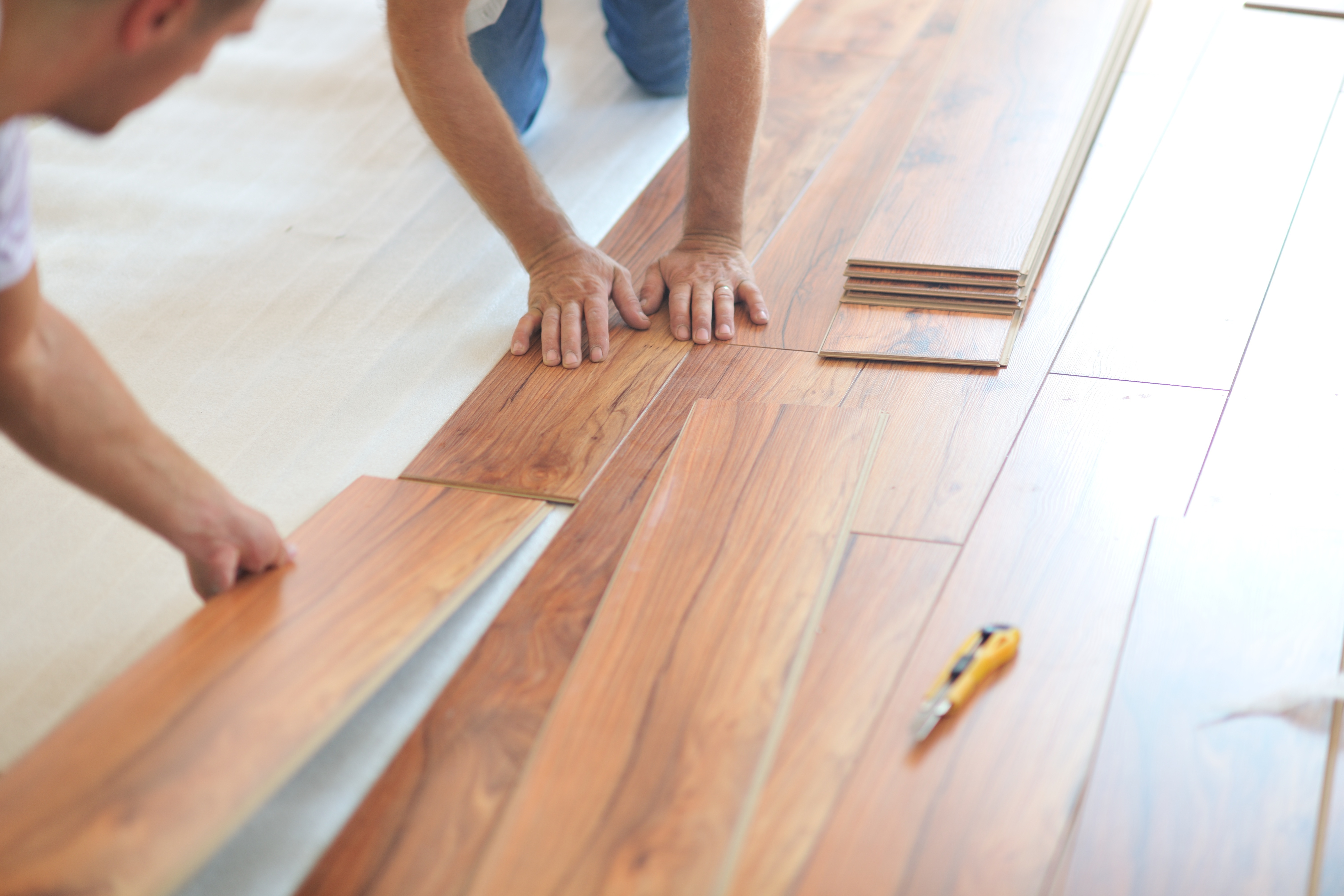 Workmen laying laminate flooring