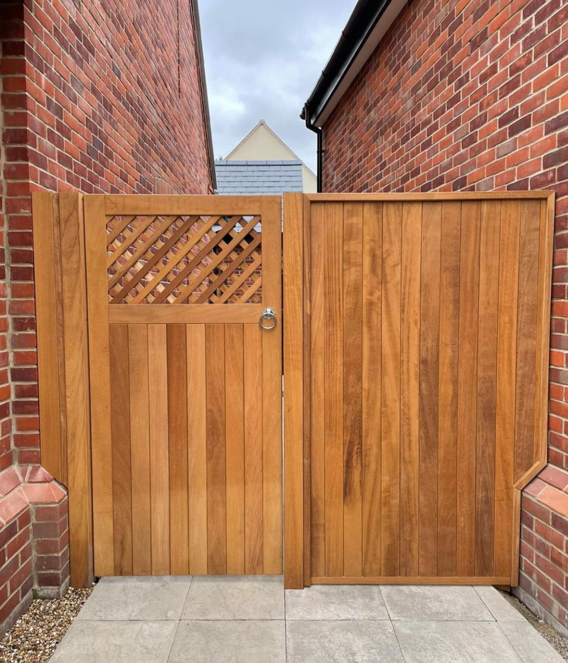 an image of a deep red, orange gate alongside a red brick home 