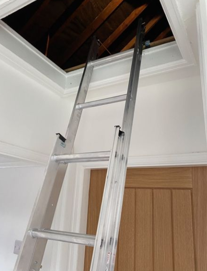 an image of a chrome ladder being used to reach the loft