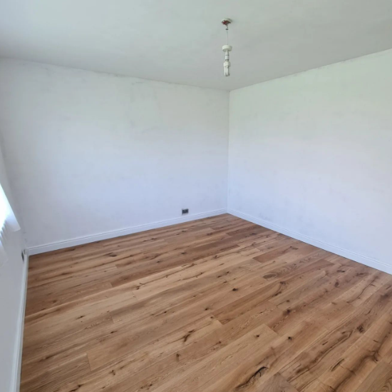 an image of a bright white wall with laminate floors