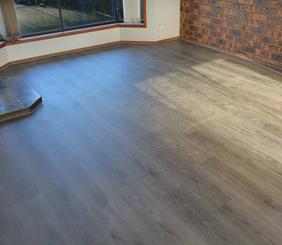 an image of a grey laminate floor in red brick room