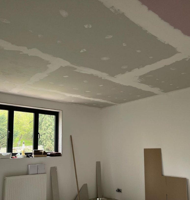 an image of a white room with black windows and painted plasterboard ceiling 