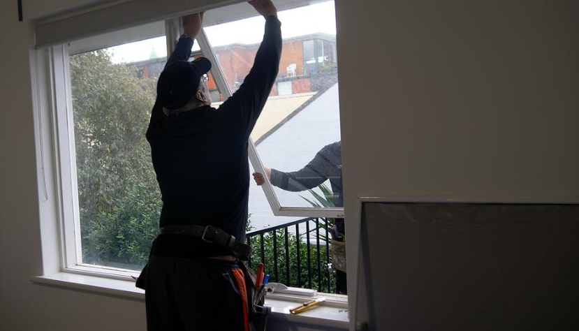 an image of a man removing window from house