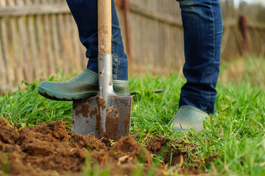 An image showing a man preparing the area for artificial grass to be installed.