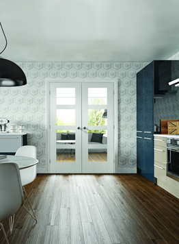 An image showing the Shaker 4 Light Internal White Primed Door pair with clear glass. Set in a kitchen to the right and a dining table to the left of the image.