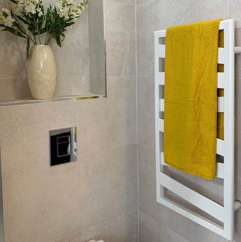 an image of a ladder towel rail with a bright yellow towel and plant pot