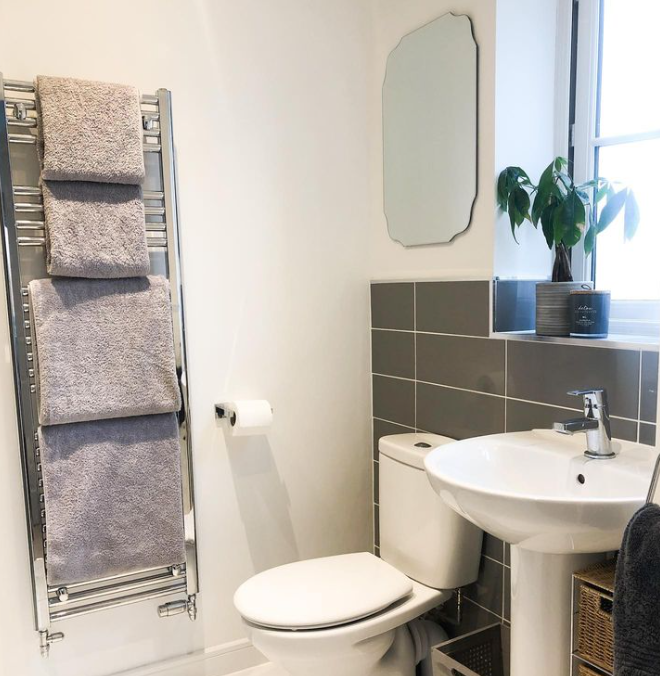 an image of a bathroom and ladder rail with towels on it. 