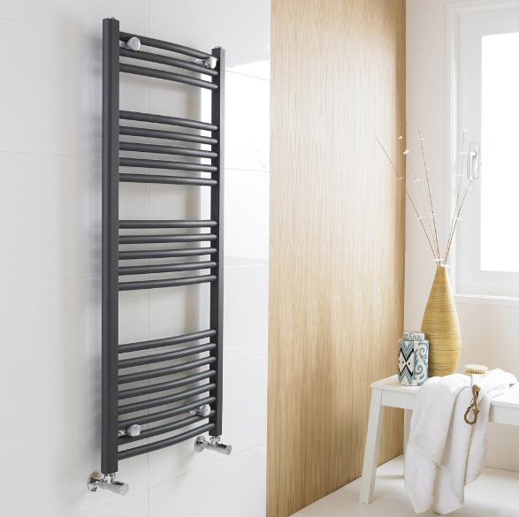 an image of a black ladder towel rail in a room with an oak wall